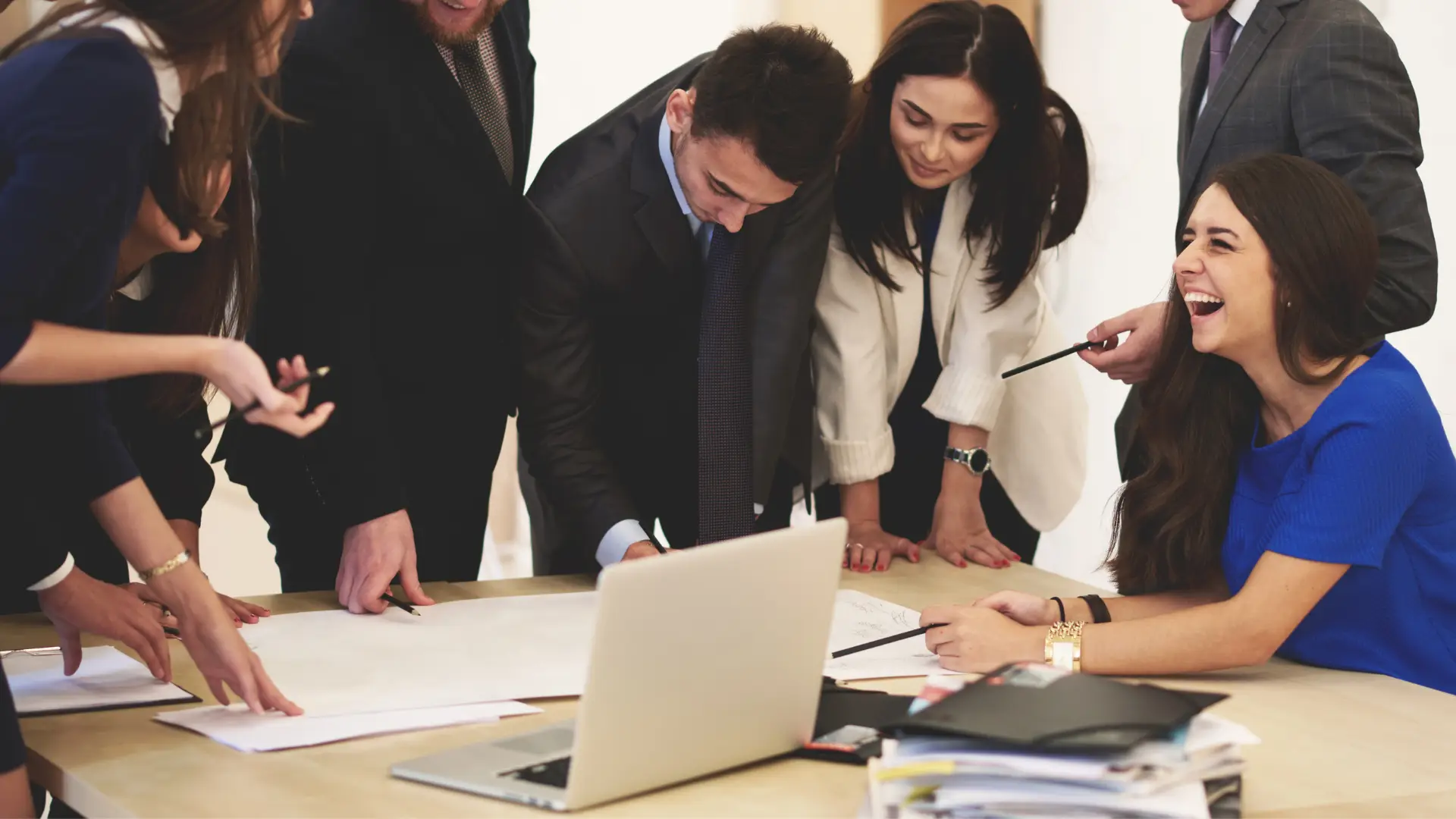 Professional team of business people collaborating around a table with laptop and design sketches